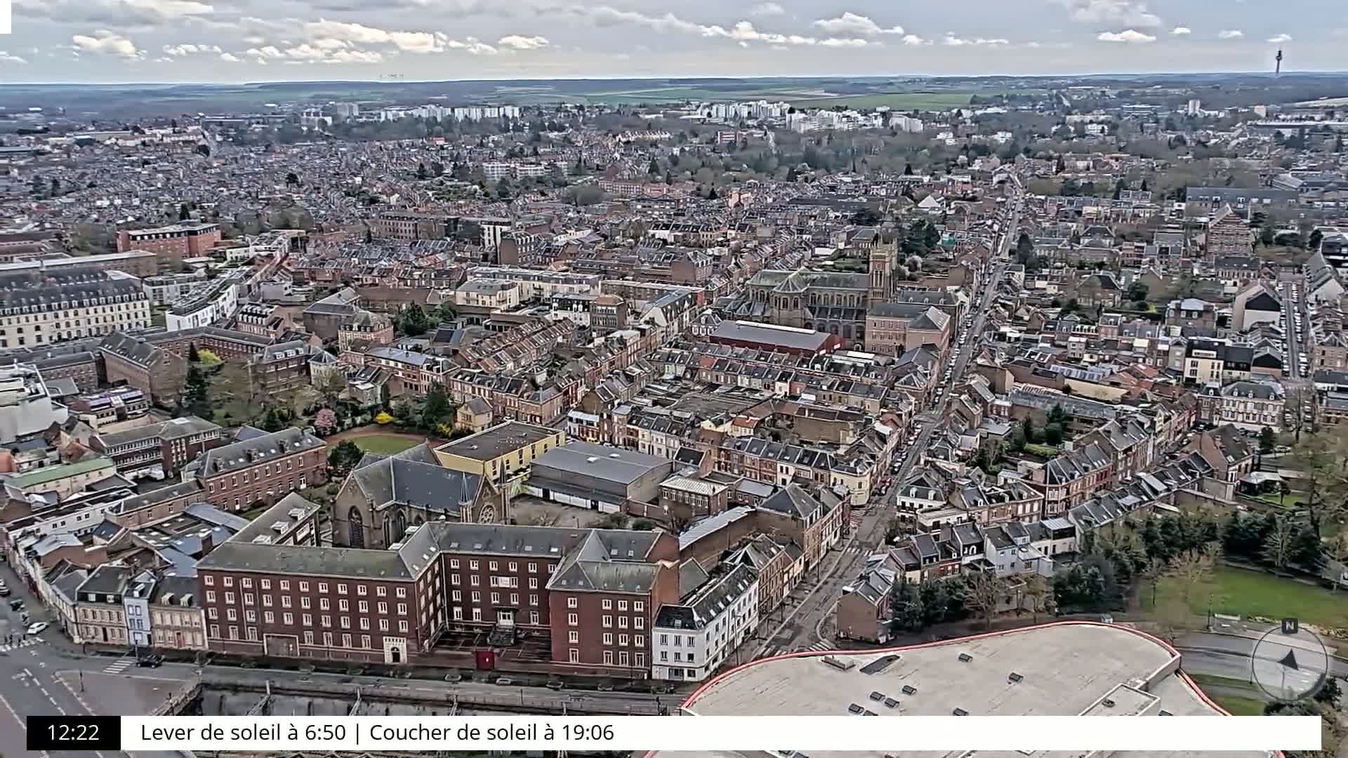 An aerial view of a densely packed city on an overcast day, showing many brick buildings and narrow streets.
