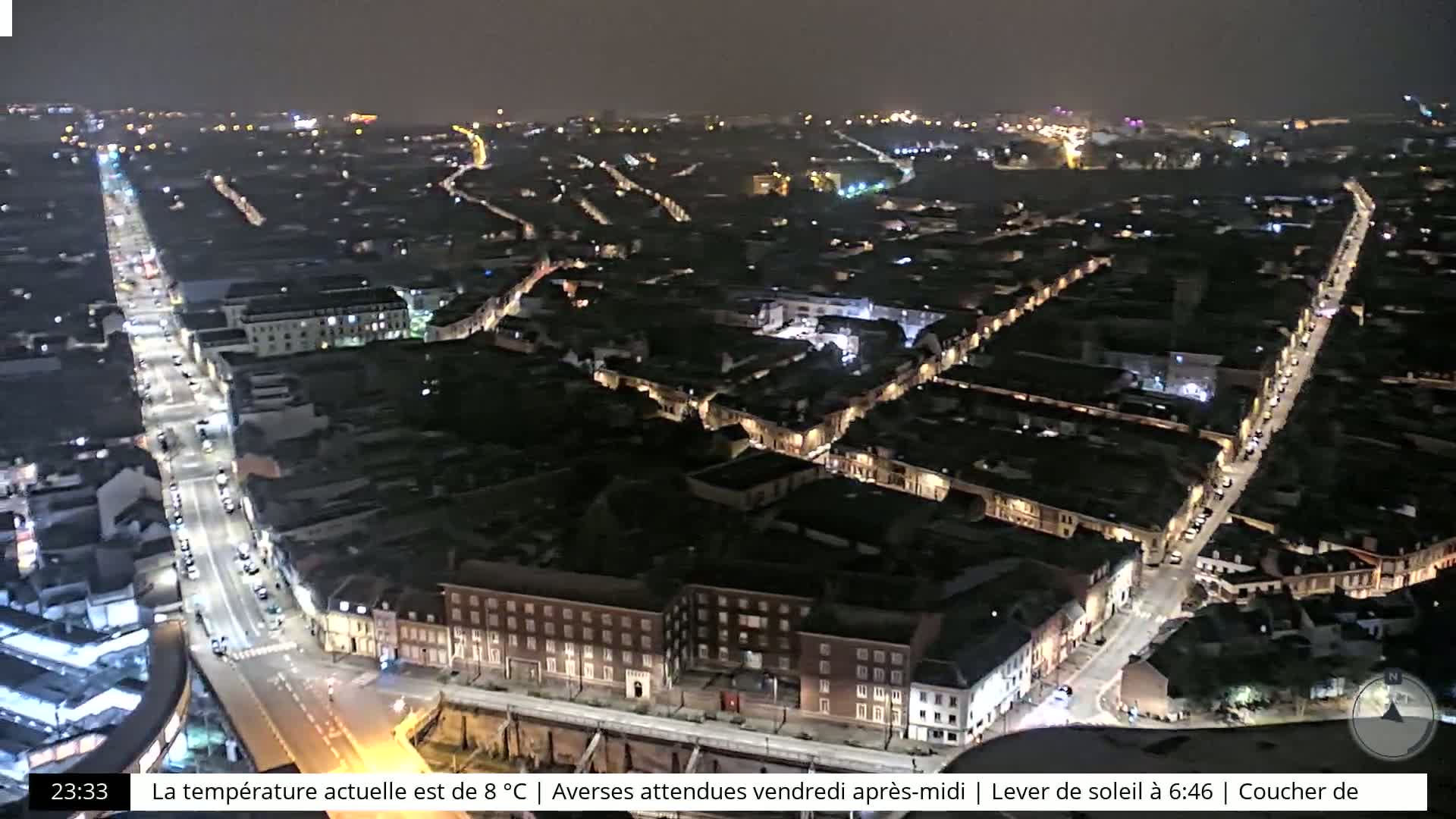 A nighttime, high-angle view of a city with illuminated streets and buildings under a dark sky.
