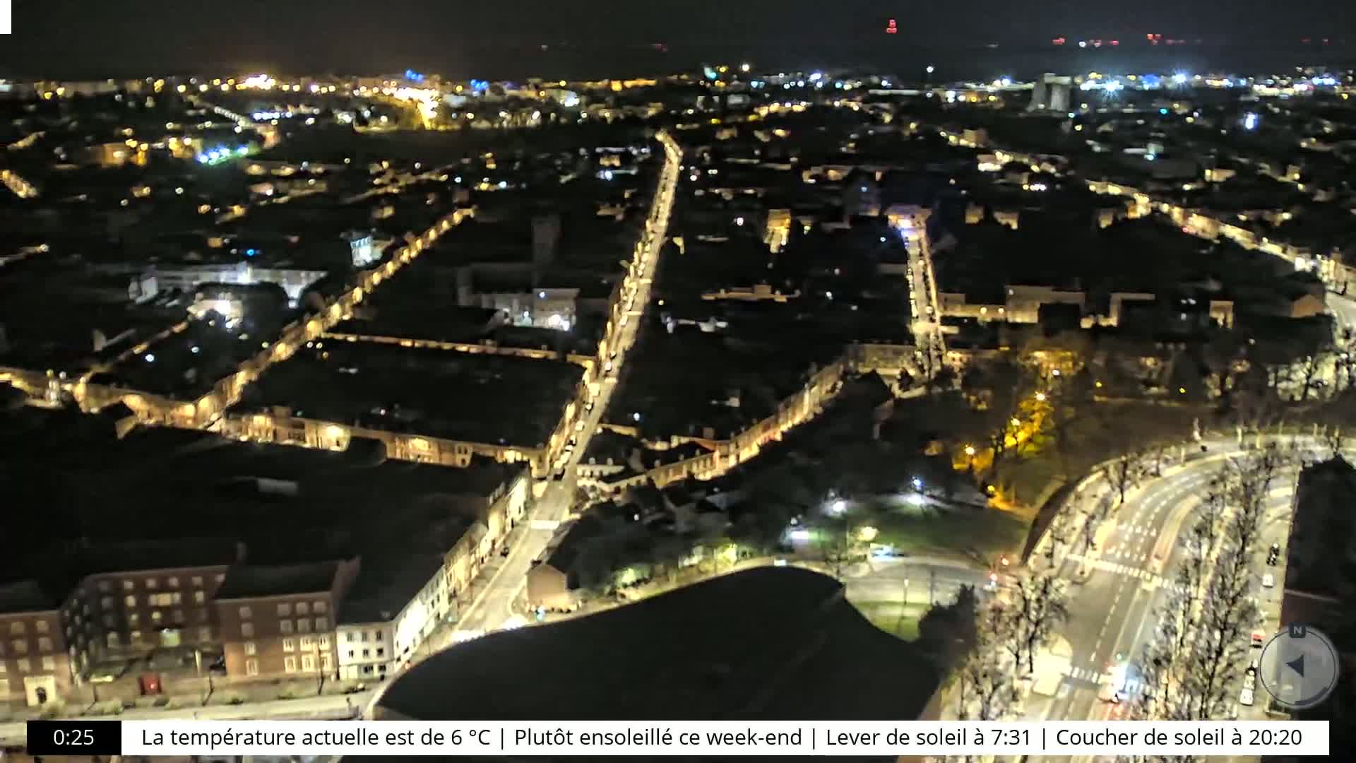 A nighttime aerial view of a city with illuminated streets and buildings.