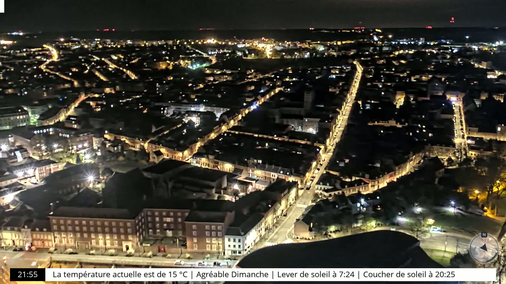A nighttime aerial view of a city with illuminated streets and buildings.