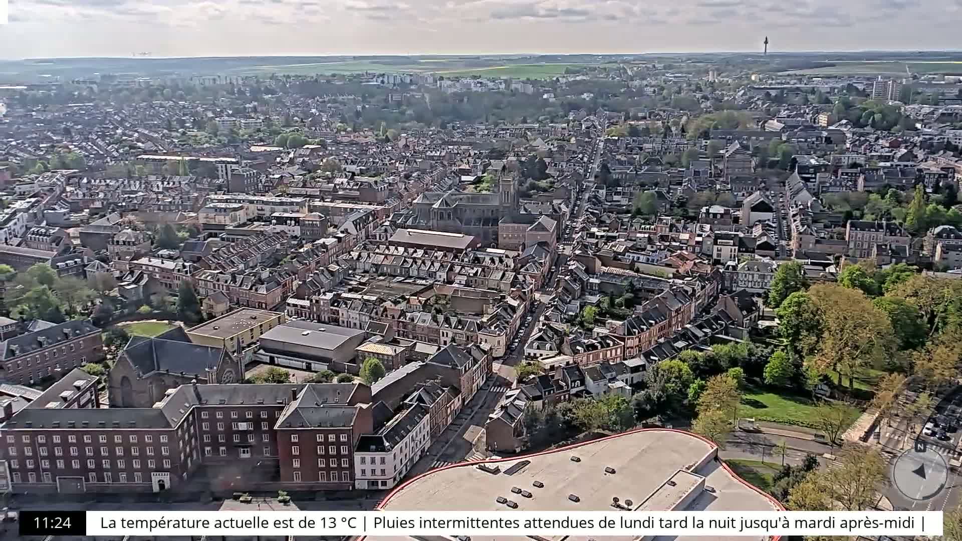An aerial view shows a dense residential area on a partly cloudy day.