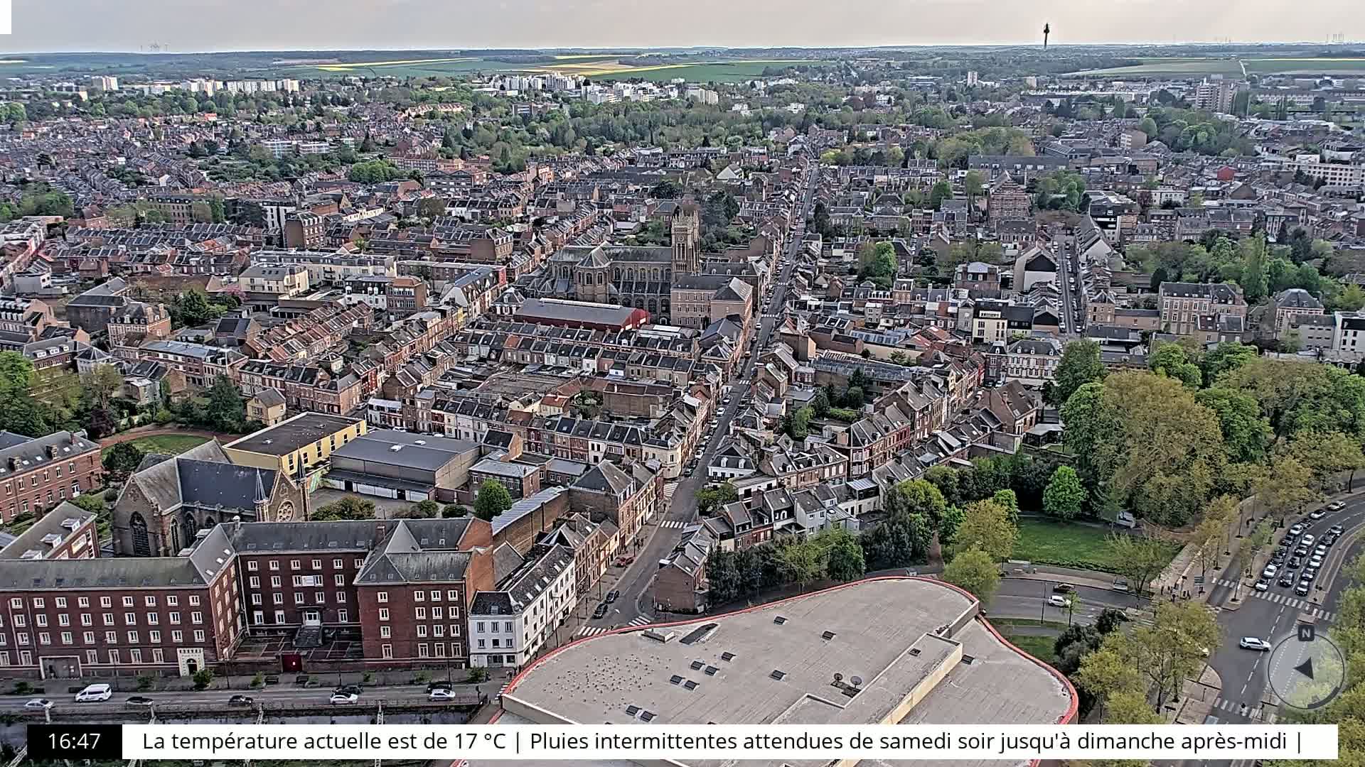 An aerial view of a city with many brick buildings under a partly cloudy sky.