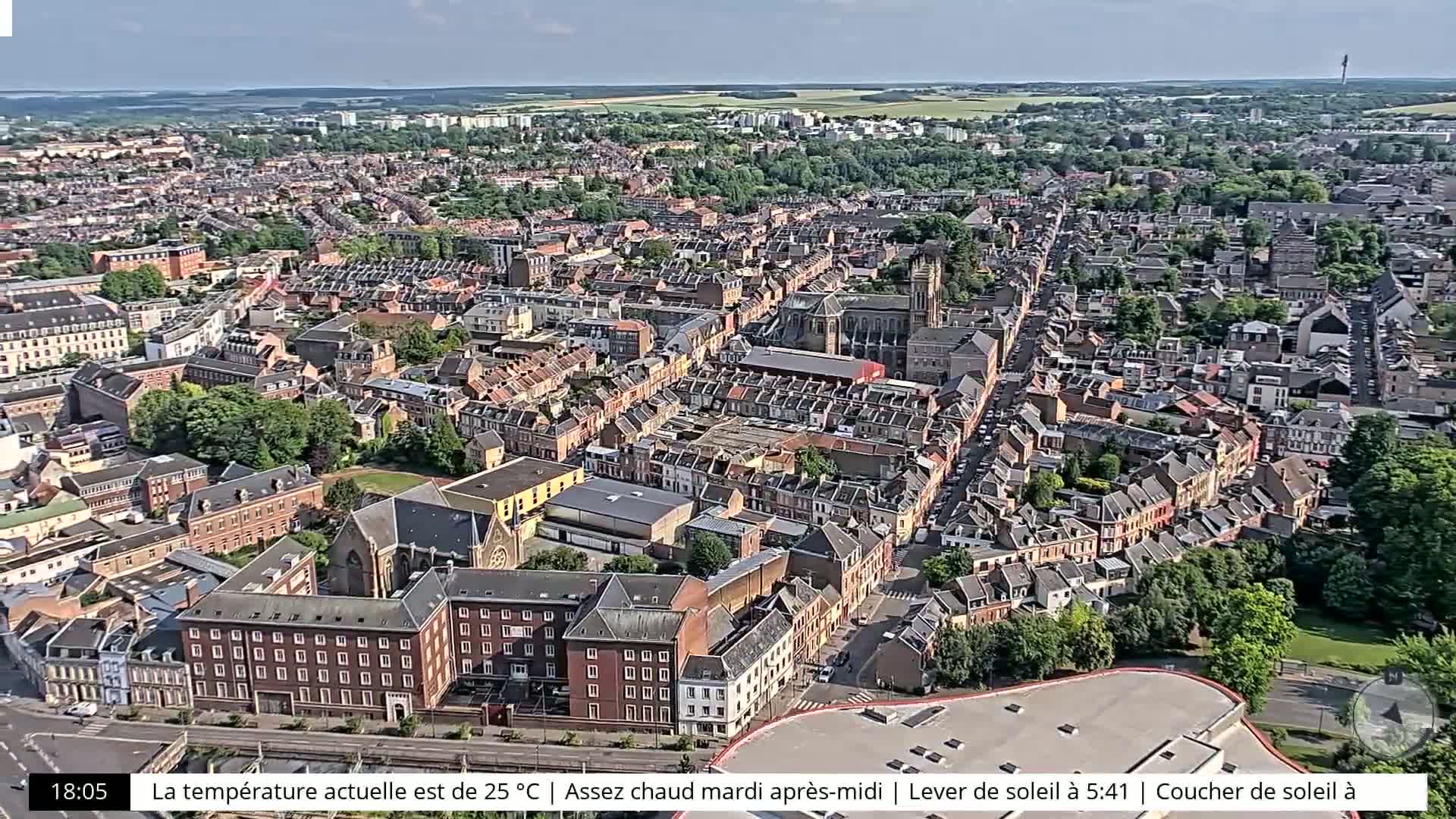 An aerial view shows a densely populated city on a partly sunny day.