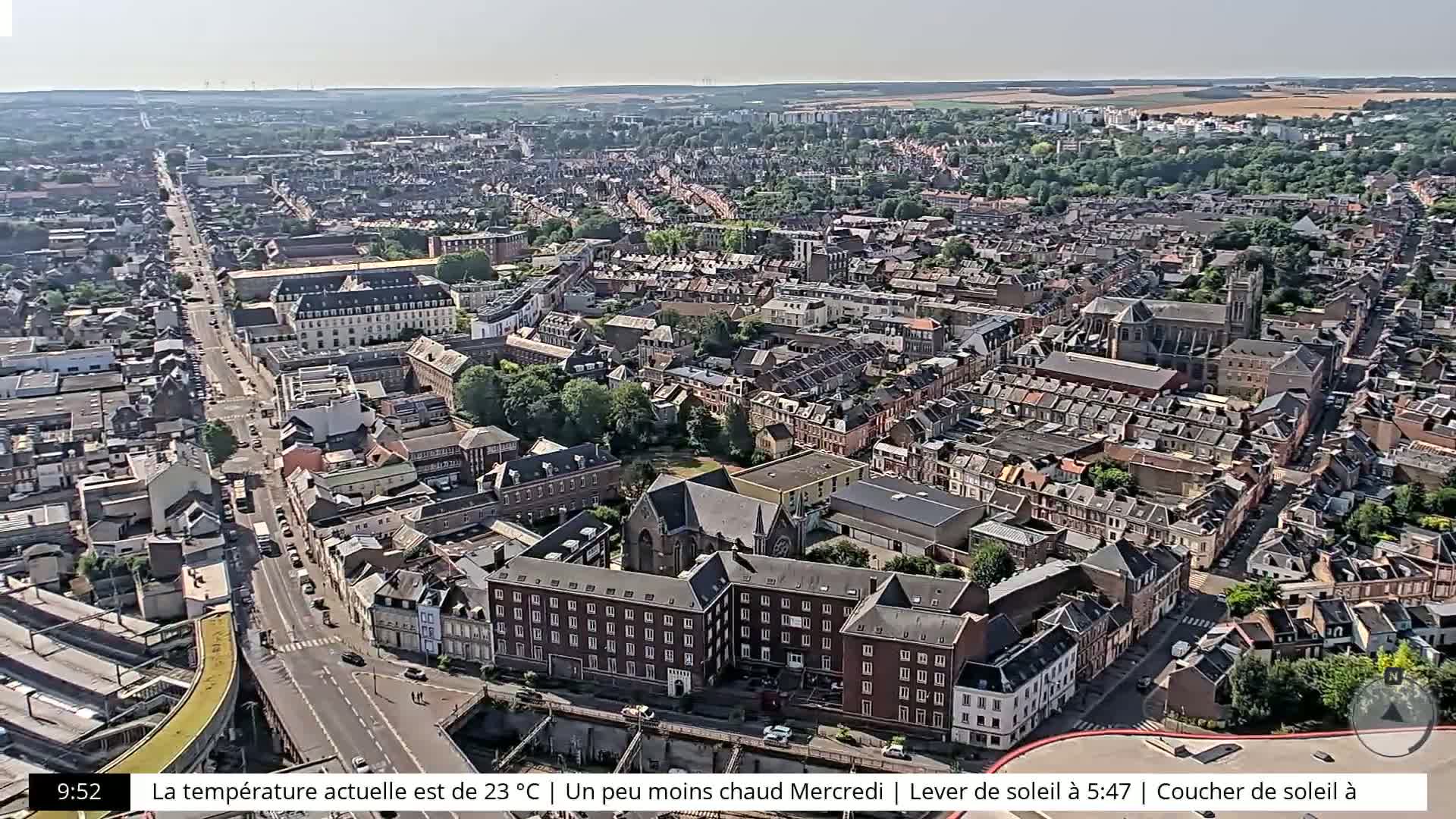 An aerial view shows a densely populated city on a sunny day.