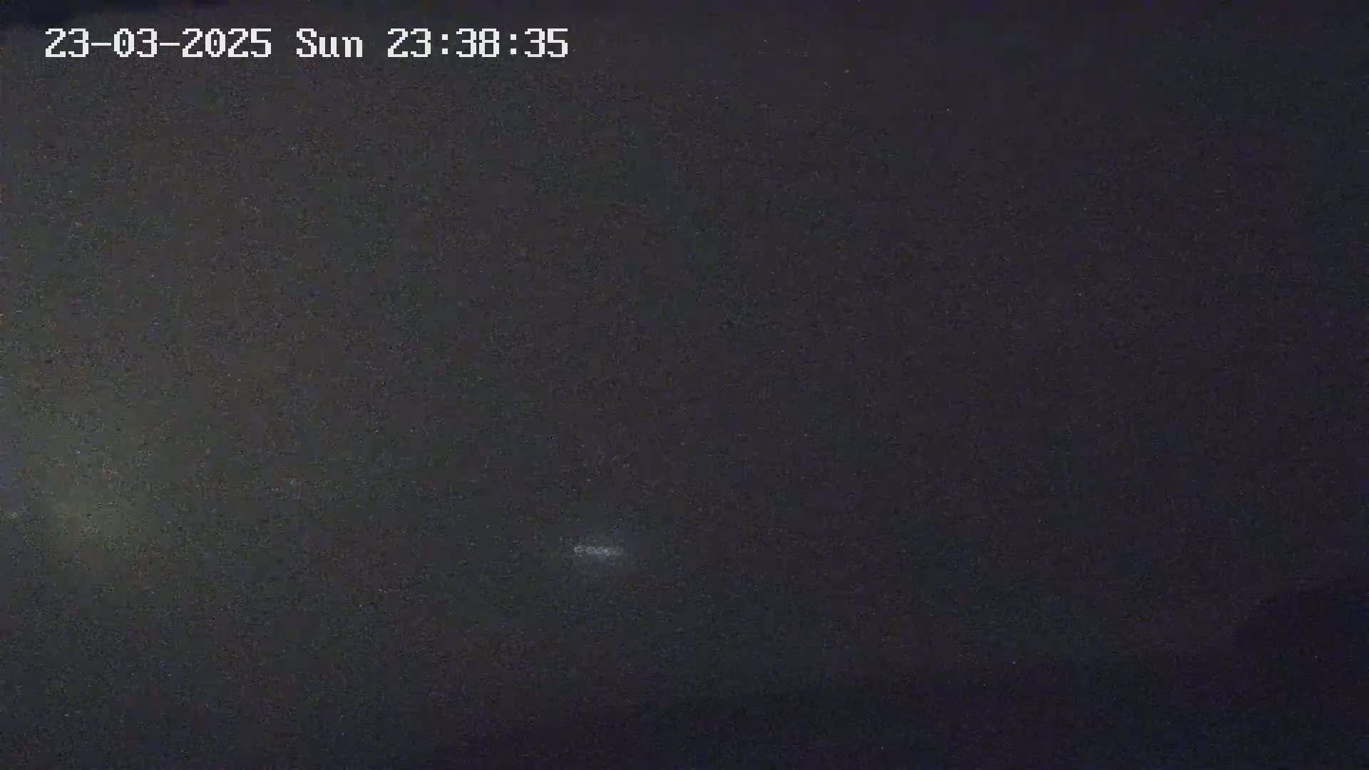 A dark night sky shows a few faint stars and a brighter spot possibly indicating a planet or other celestial body.