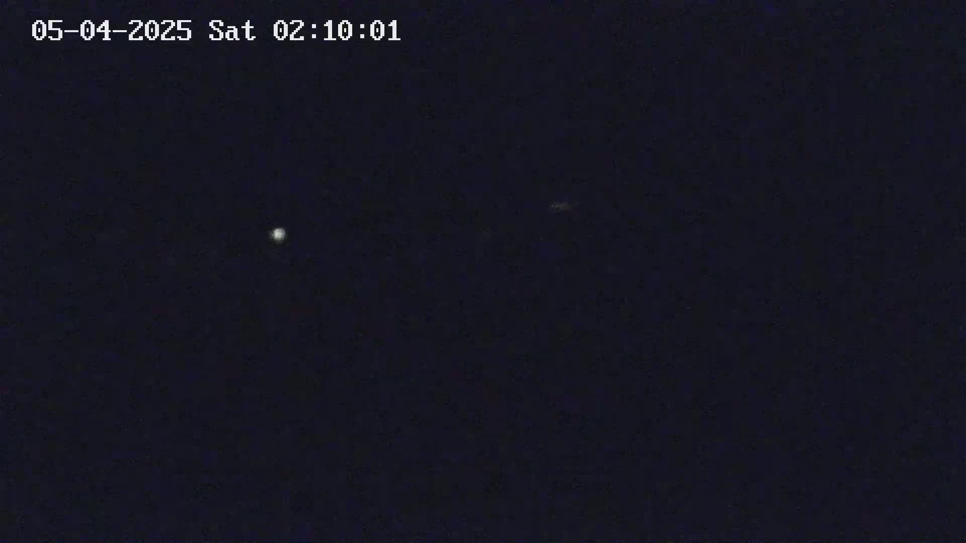 A dark night sky shows a few faint lights.