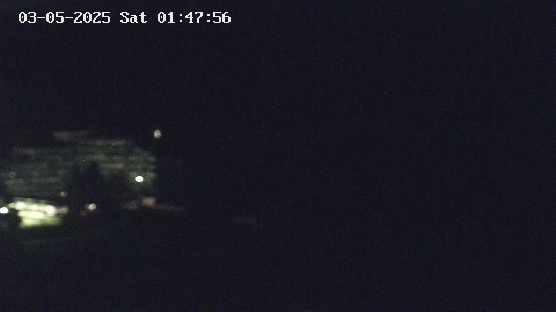 A blurry, dimly lit image shows a building at night.