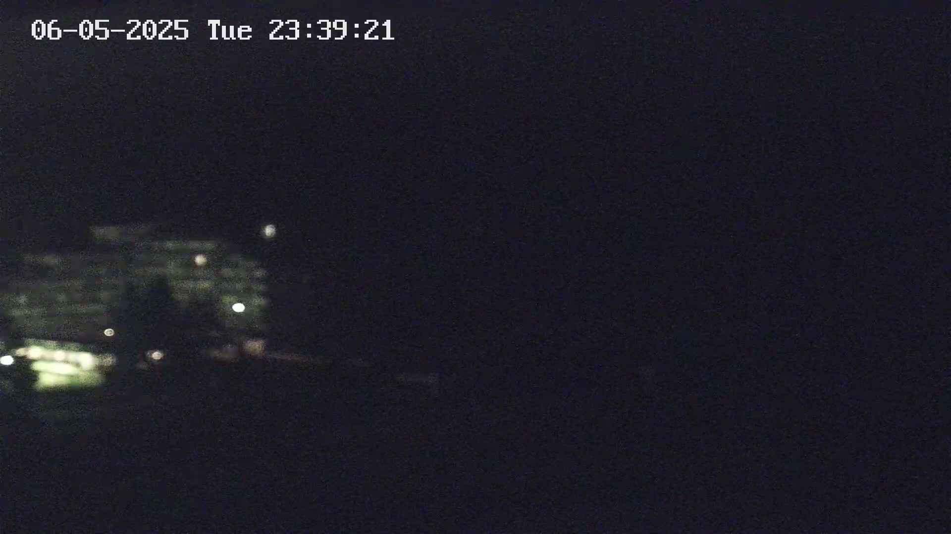 A dimly lit, large building is visible in the distance at night.