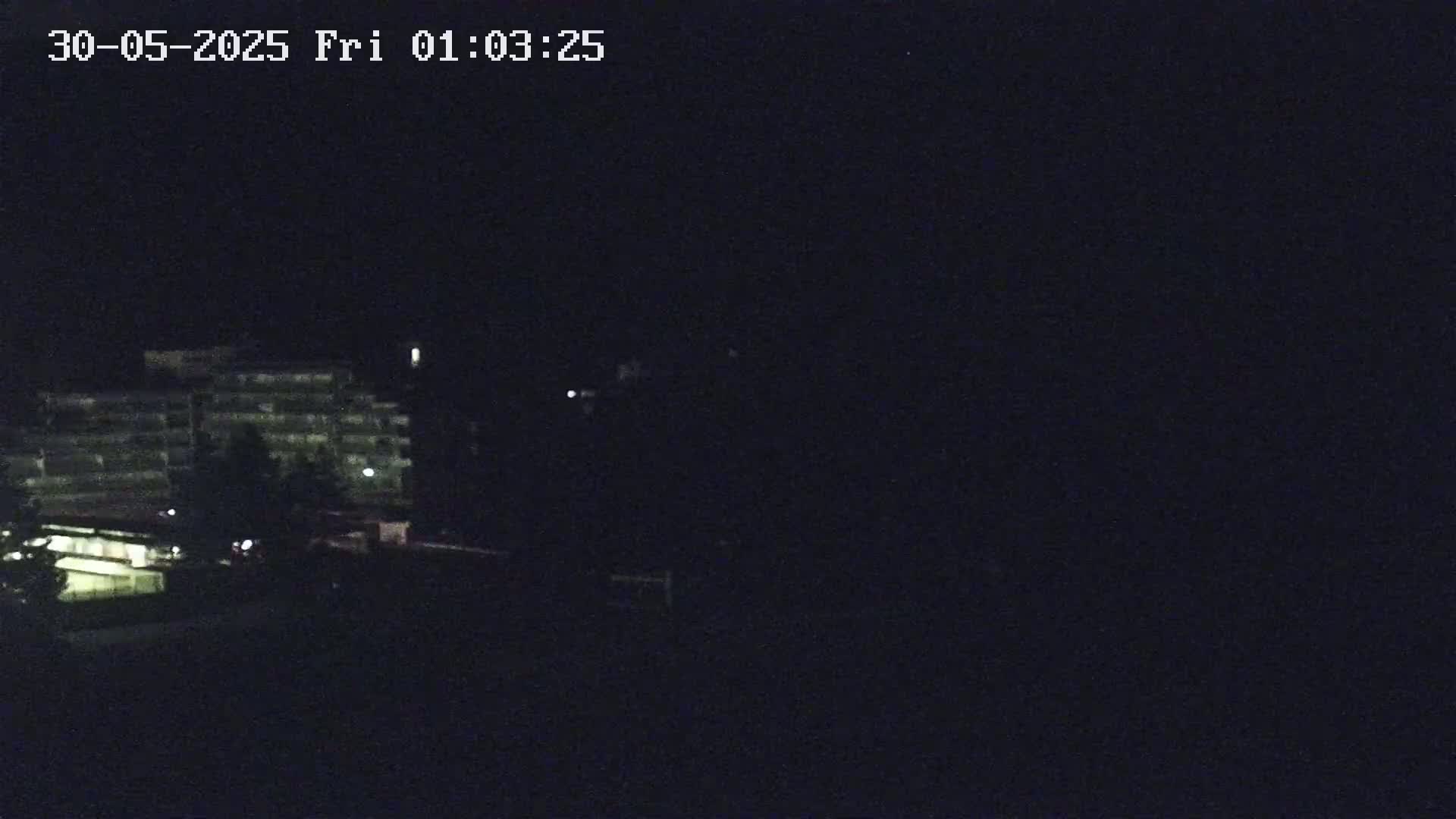 A dimly lit multi-story building is visible at night.