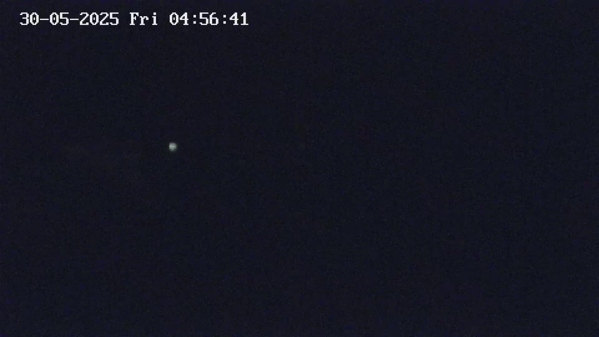 A dimly lit night scene shows a single, small, bright light in a dark sky.