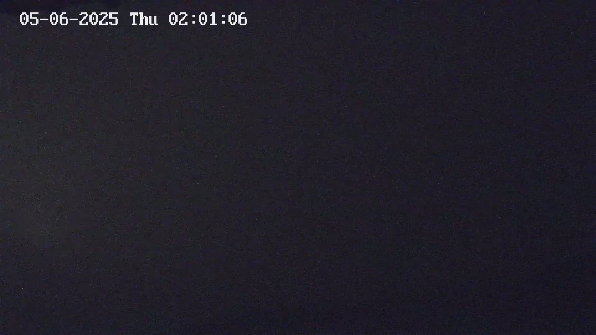 A dark, nighttime image shows a uniformly dark gray-black surface.