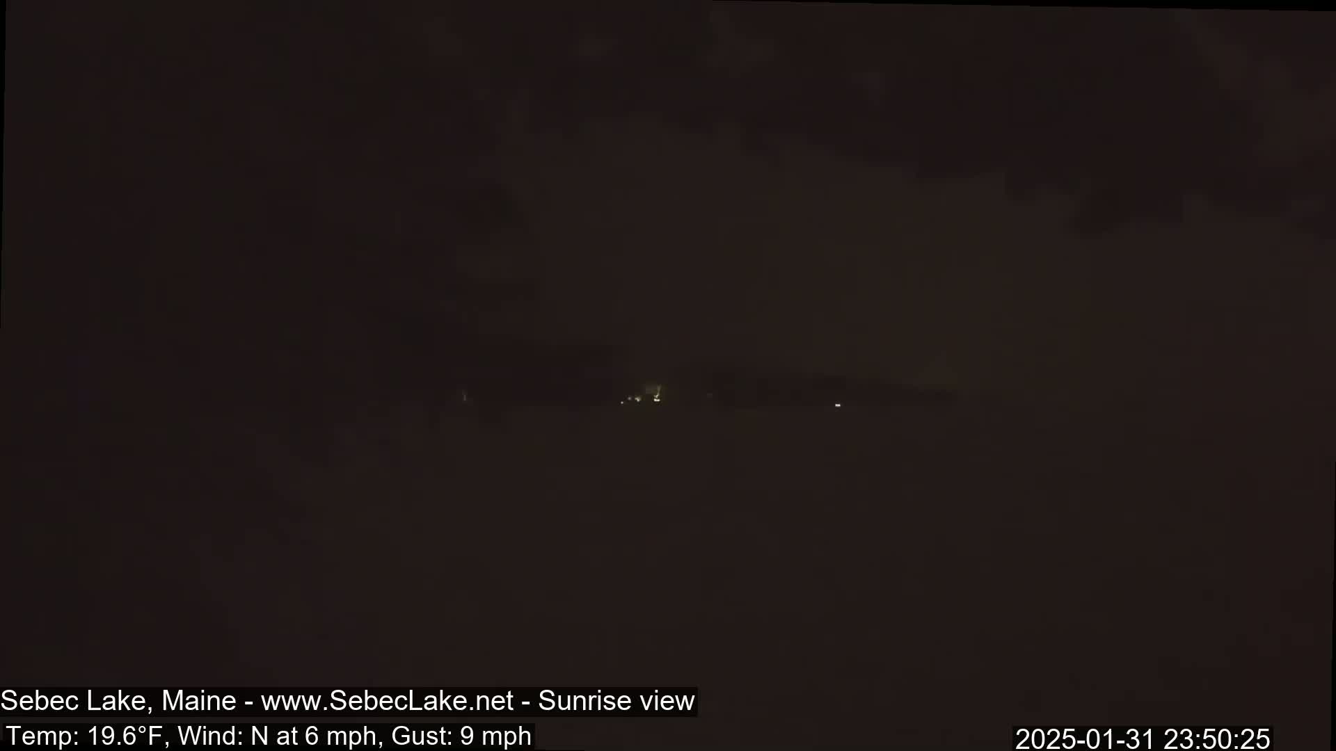 A dark, nighttime scene shows a distant, faintly lit horizon under a cloudy sky, with a north wind at 6 mph and gusts up to 9 mph.