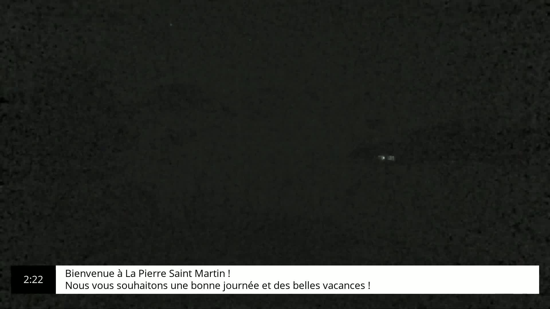 A very dark image shows a small, faint light in the distance.
