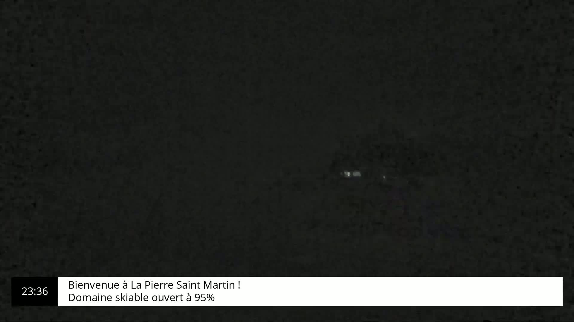 A dark, possibly nighttime, image shows a very faint, blurry light source in the distance.