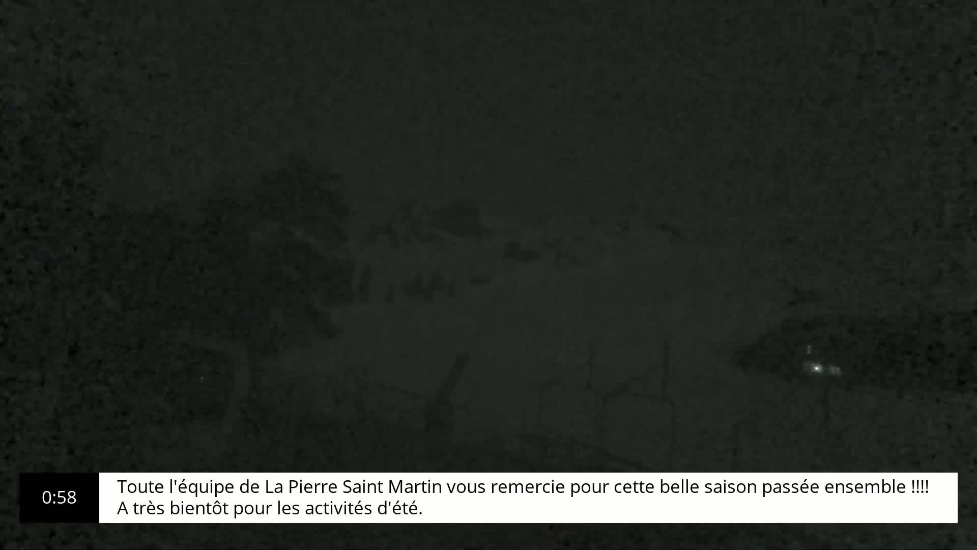 A very dark, blurry image shows indistinct shapes that could be trees or structures under a nighttime sky.