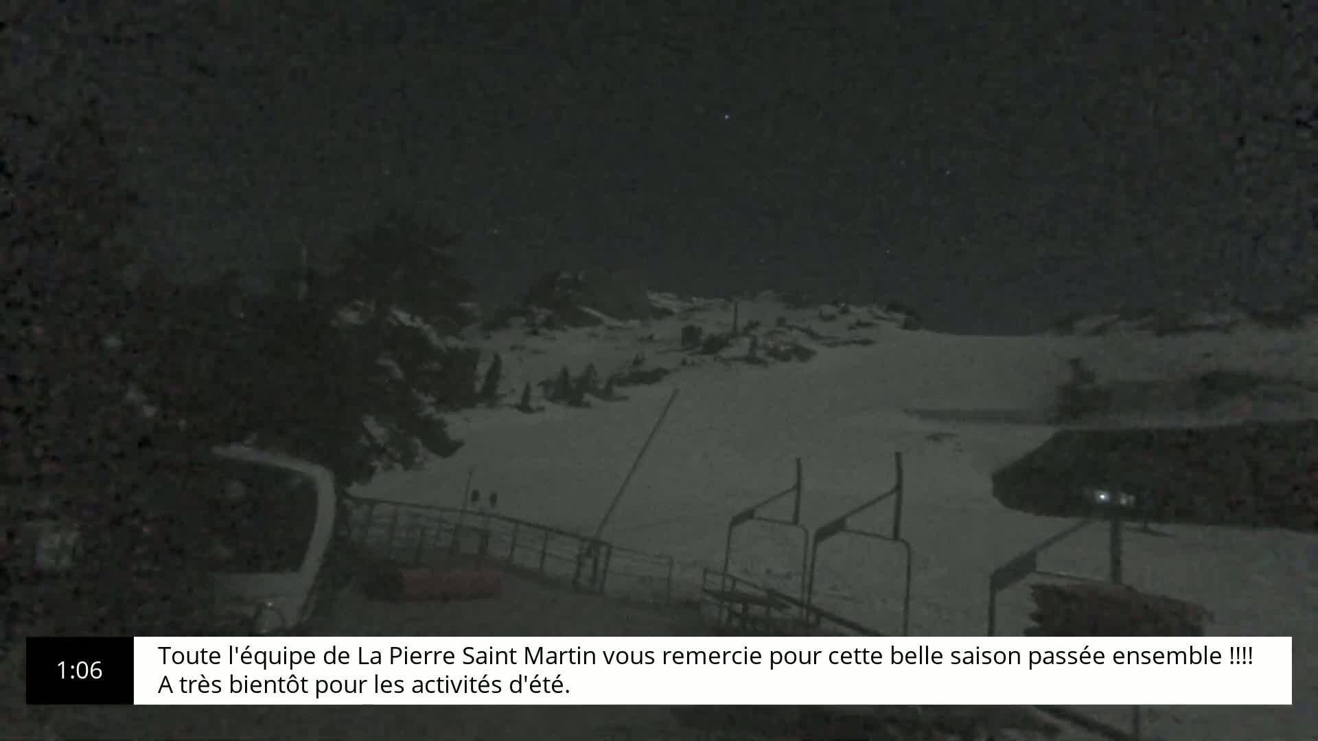 A snow-covered ski slope is visible at night under a clear, starry sky.