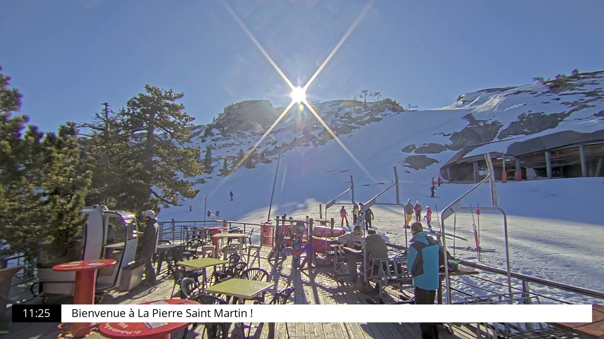 The image displays a snow-covered ski resort on an overcast and snowy day, featuring heavily laden pine trees, a gondola cabin, and several empty ski lift chairs extending into the foggy distance.