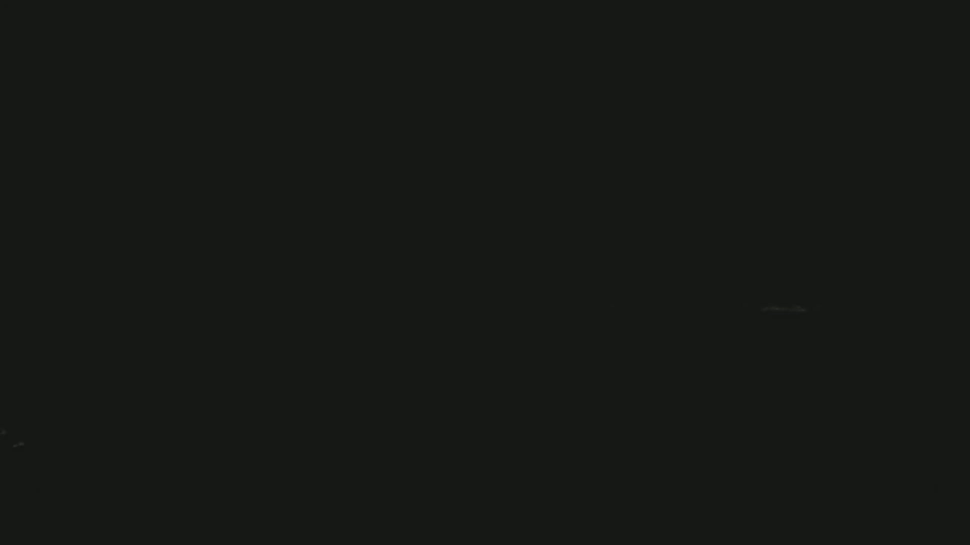 The image is almost entirely black, with a few faint, barely visible specks of light.
