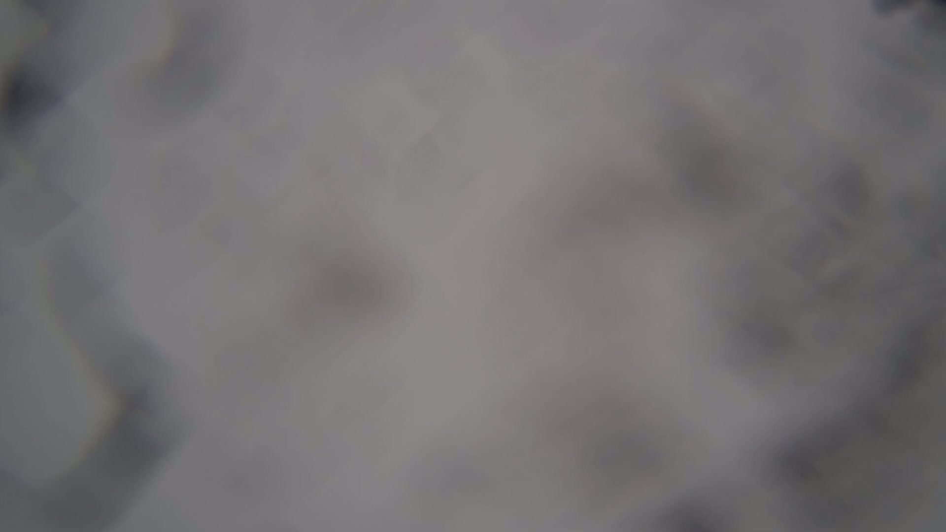 A blurry, out-of-focus image shows a mostly gray and white surface.