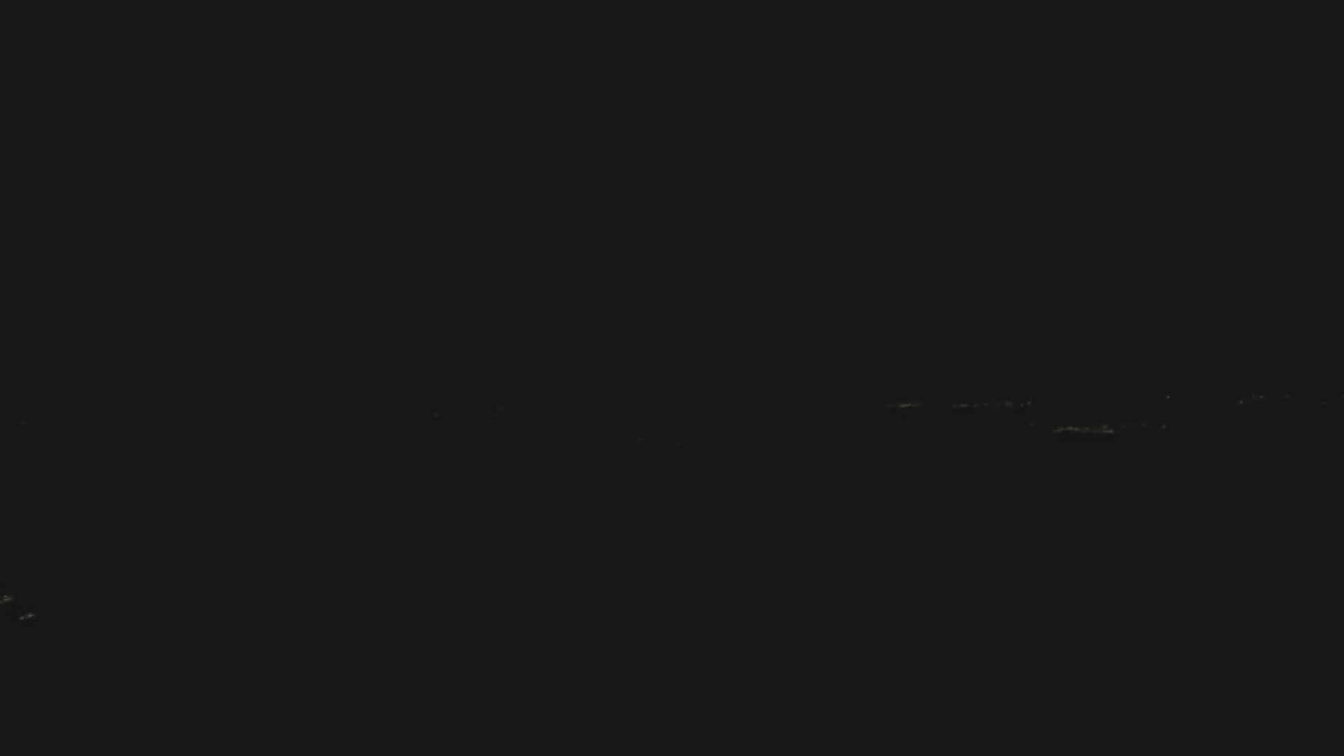 A dark image shows a faint horizontal line of light possibly representing a distant city skyline at night.