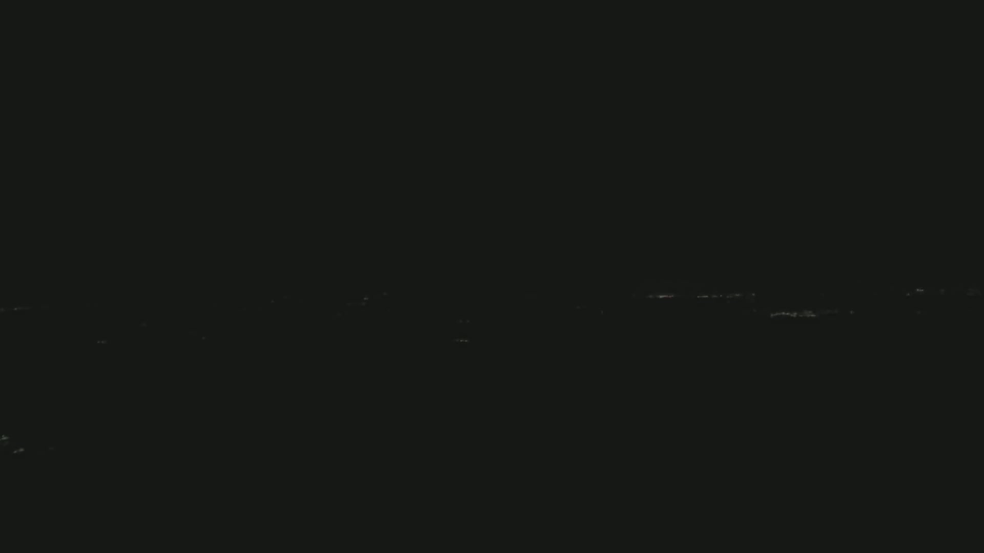 A long line of faint, distant lights is visible at night.