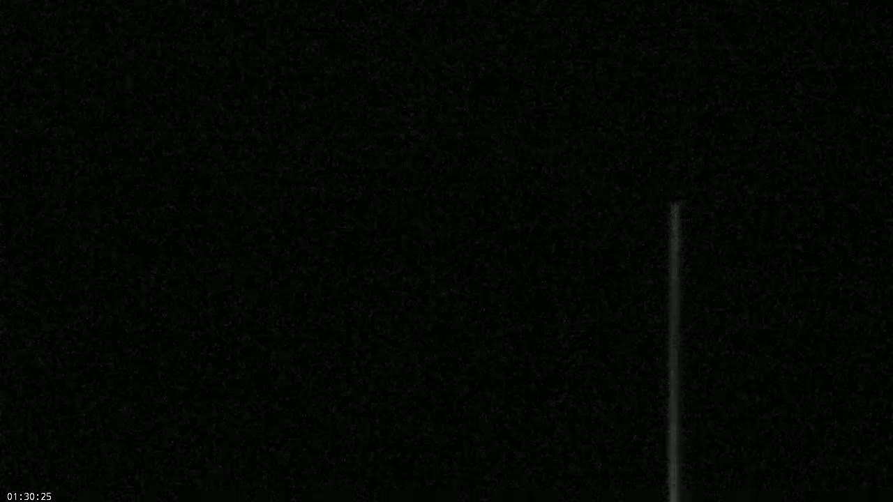 A very dark image shows a thin, vertical, light-grey line against a mostly black background.