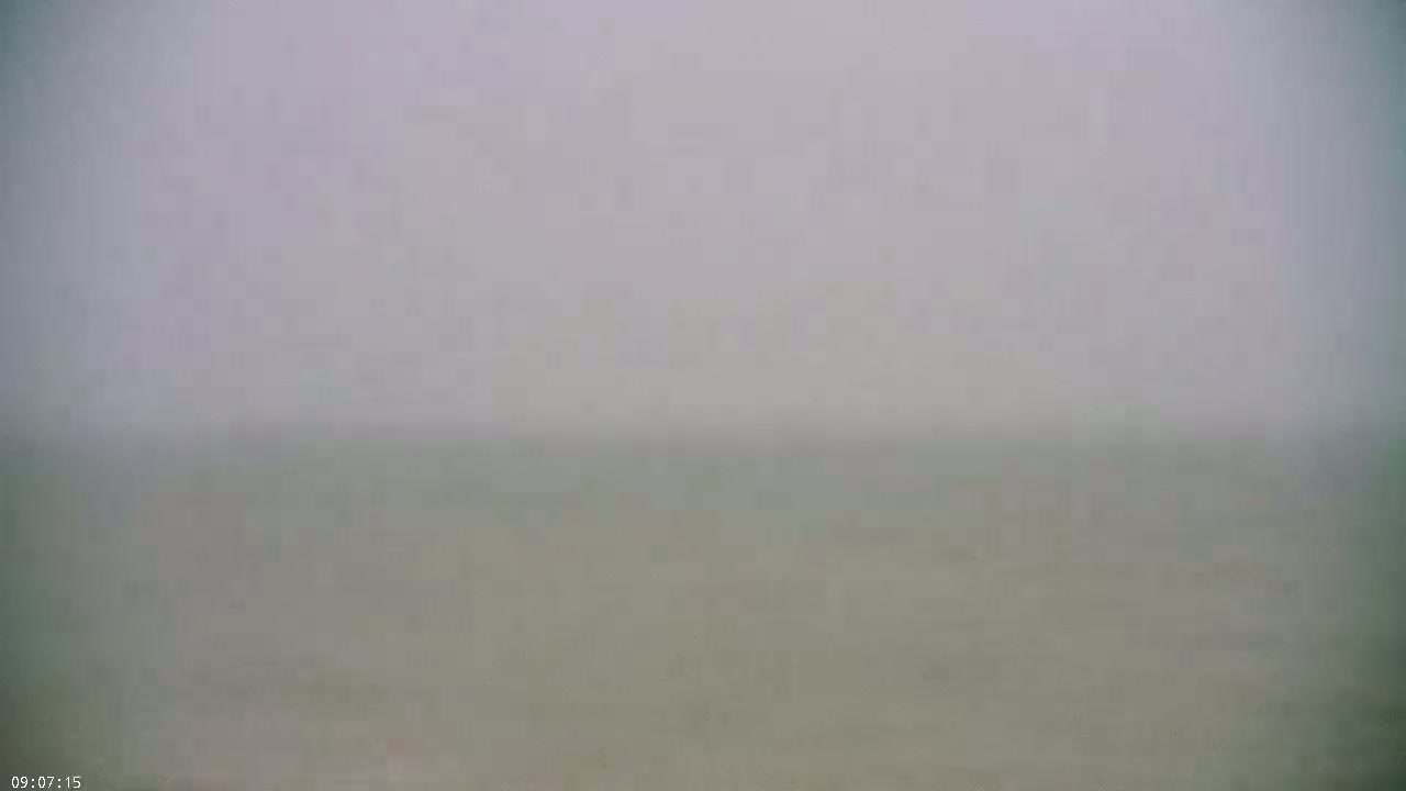 A hazy, foggy view of a body of water extends to the horizon.