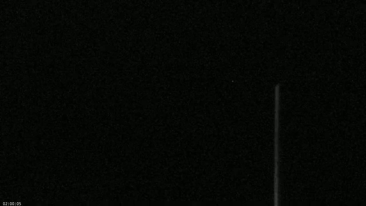 A mostly dark image shows a thin, vertical, bright line against a dark, grainy background.