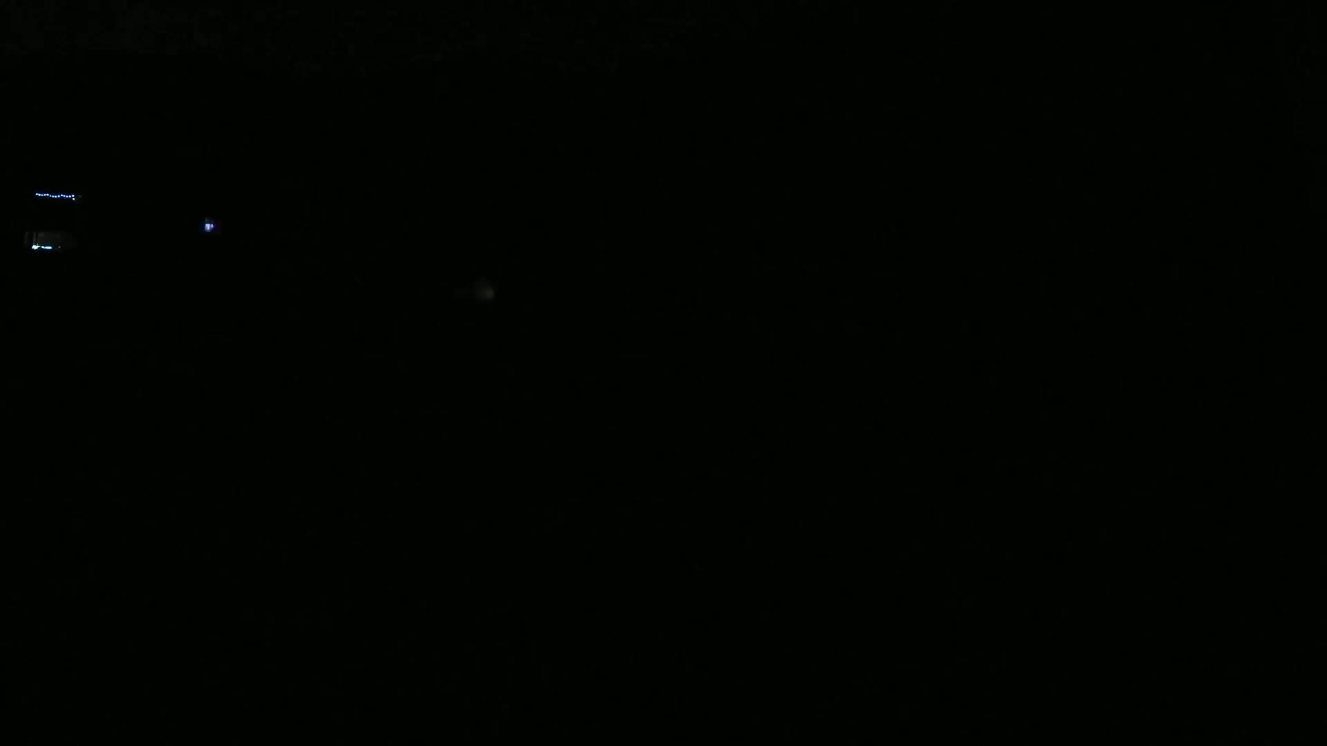 Faint lights are visible in the overwhelming darkness of night.
