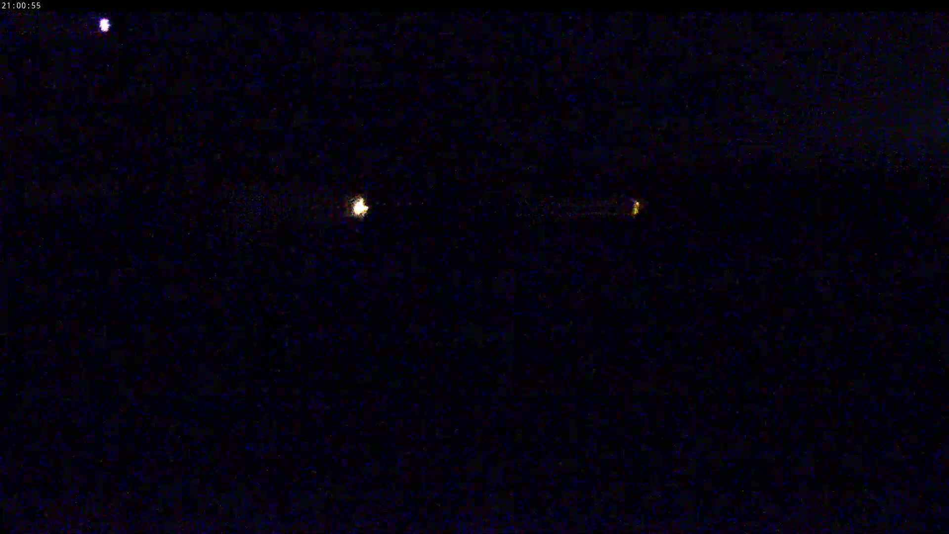 A nighttime image shows two distant lights in the dark sky.