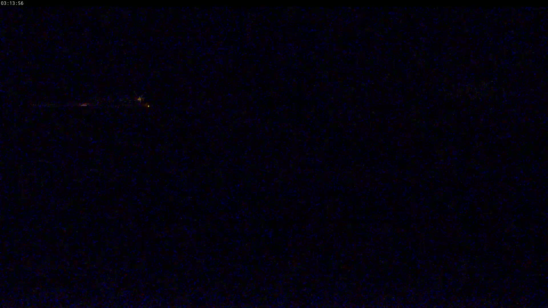 A nearly indiscernible, low-light image shows a faint horizontal line of light in the distance against a dark, possibly nighttime background.