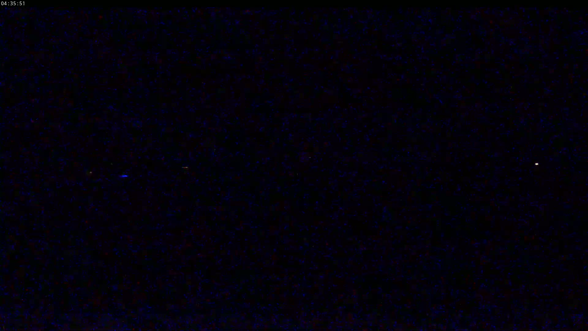 A dark, nighttime sky shows several faint points of light.