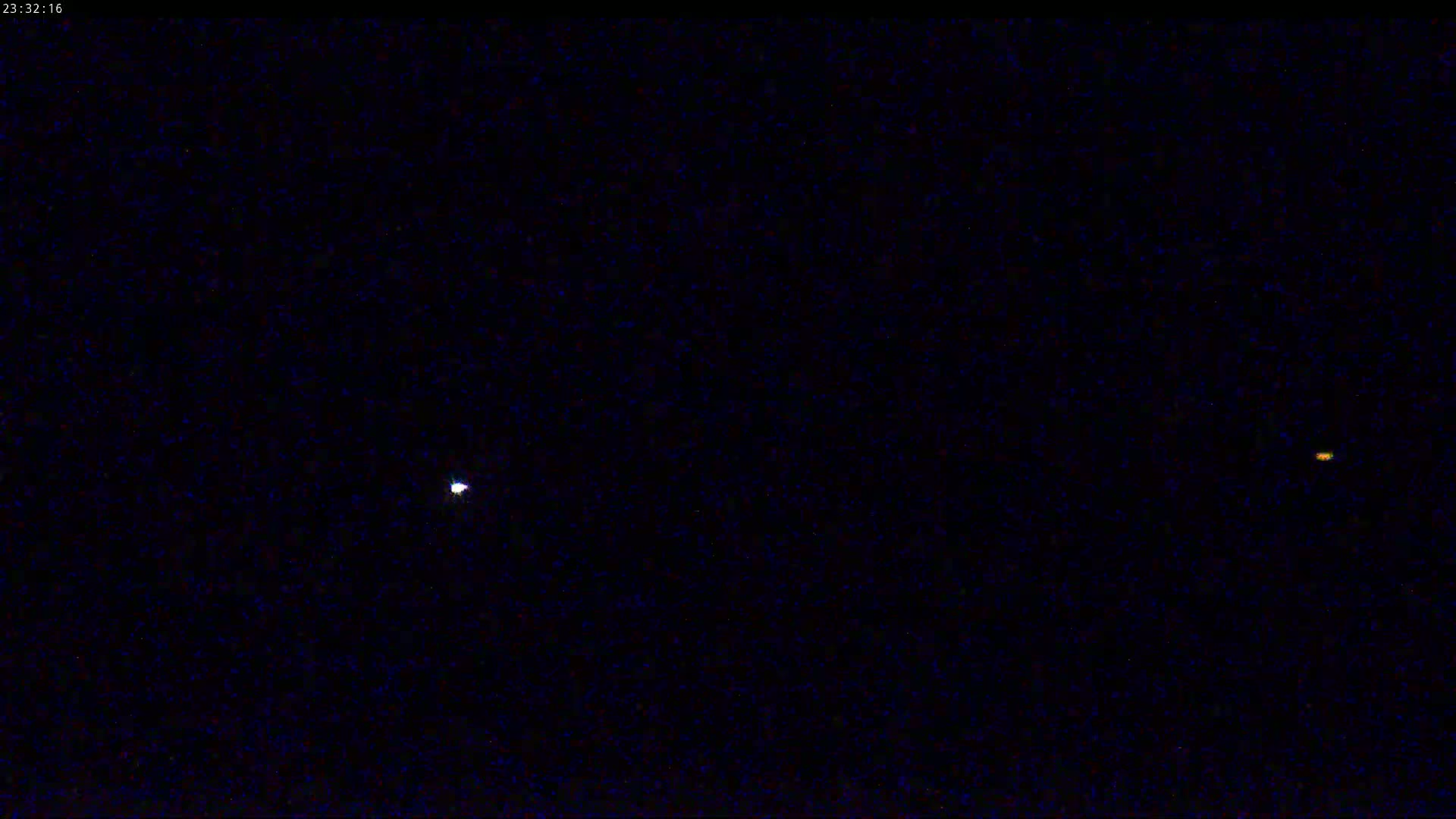 A nighttime image shows two bright celestial objects in a dark sky speckled with stars.