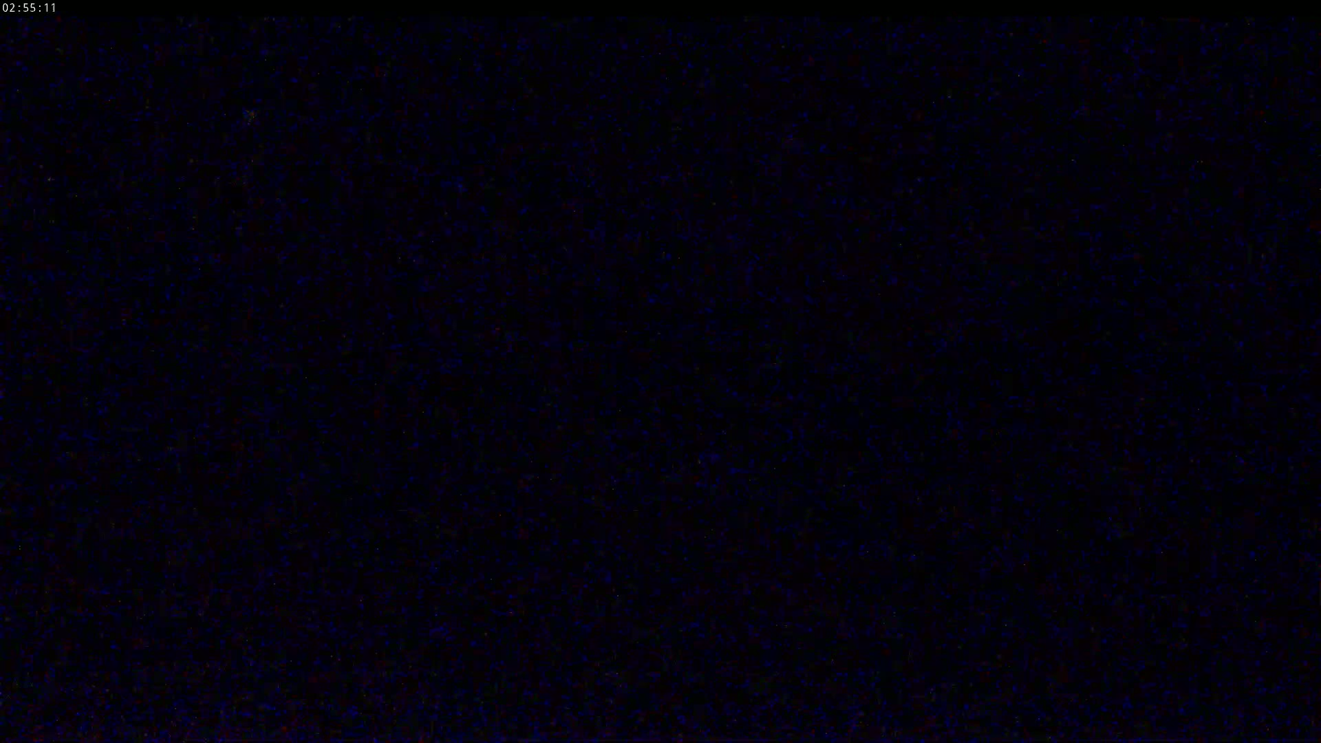 The image shows a completely dark screen with subtle speckles of blue and other dark colors.