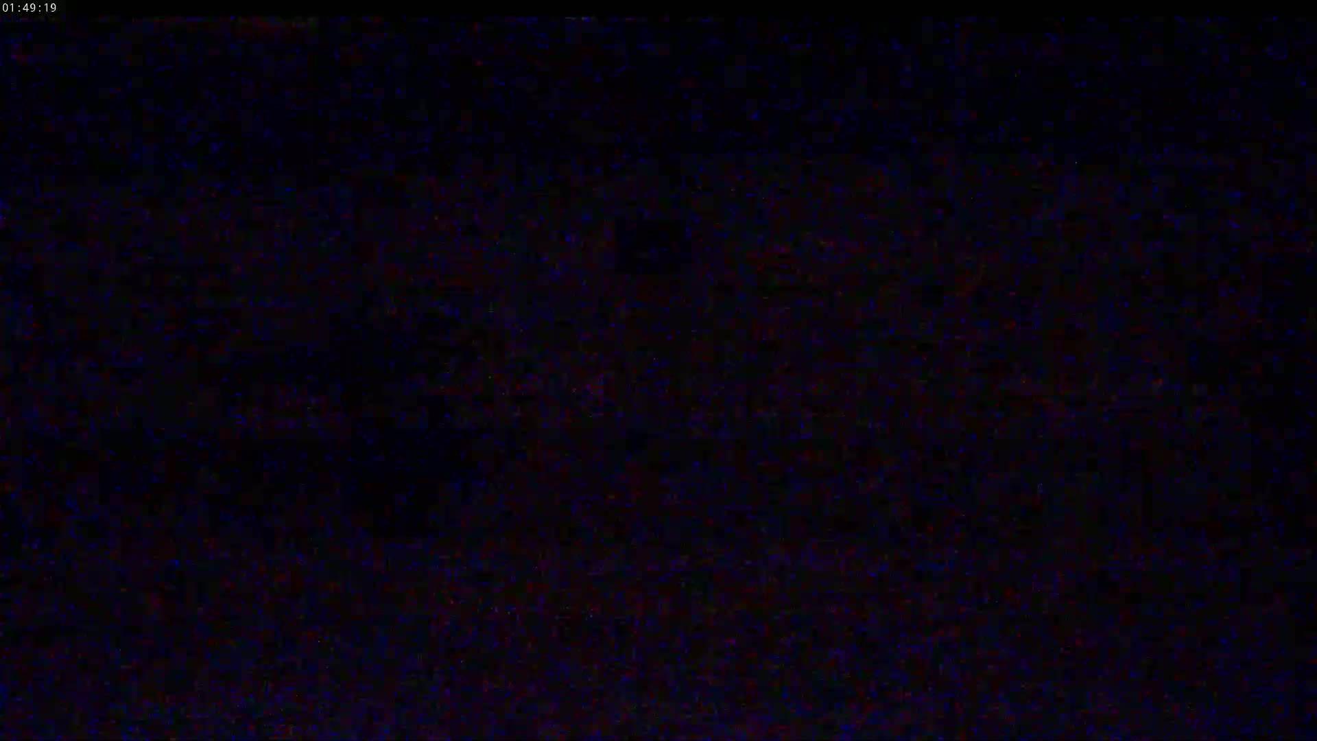The image shows a completely dark screen with slight static interference.