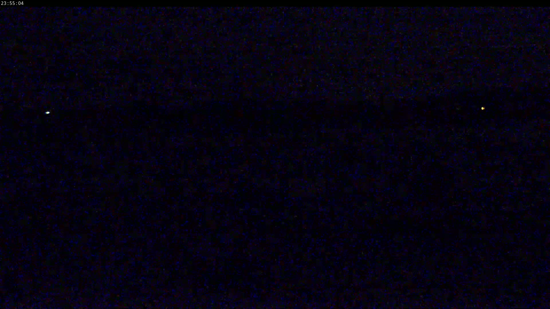 A dark night sky shows two distant bright lights.