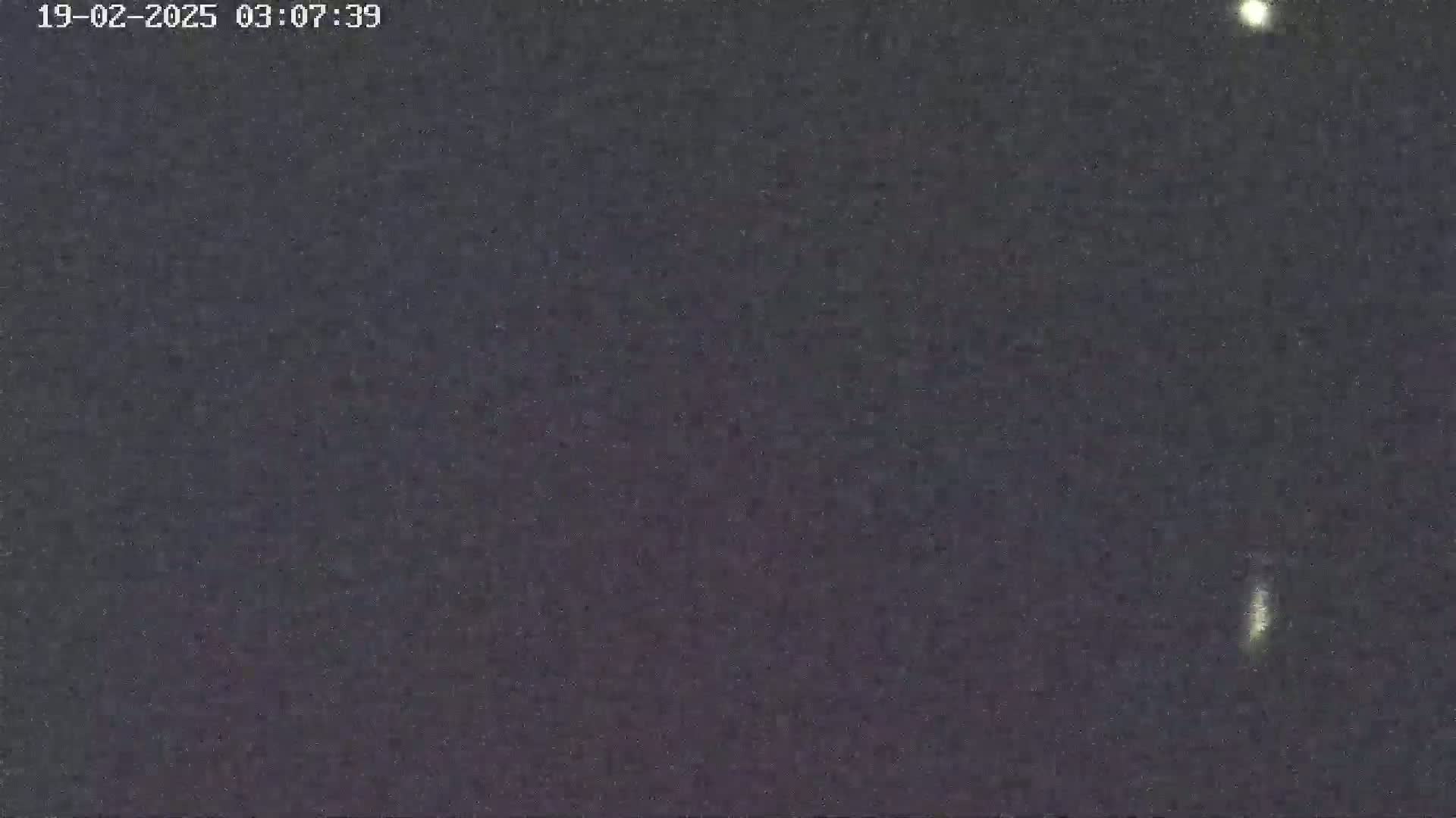 A dark, nighttime sky shows a few faint lights.