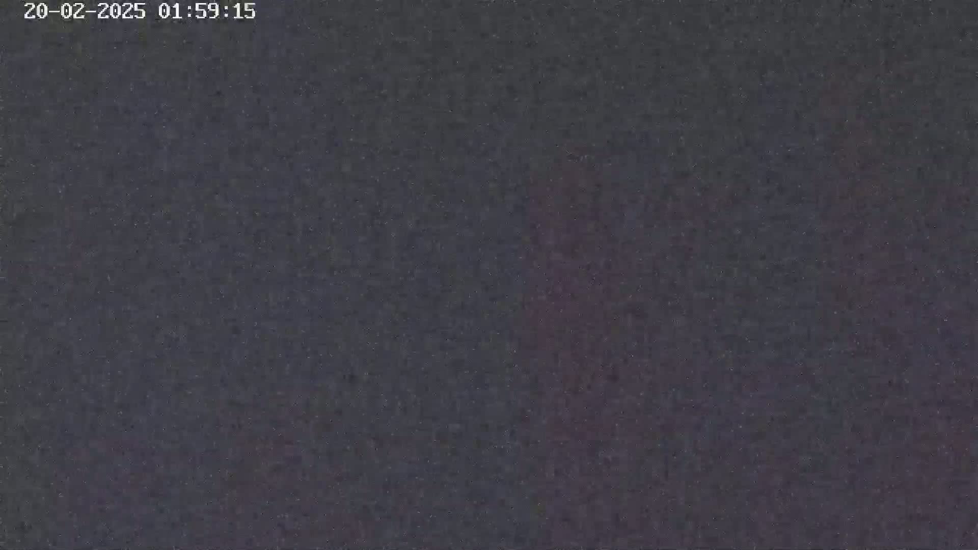 The image shows a dark, grainy, and blurry view of a nighttime scene.