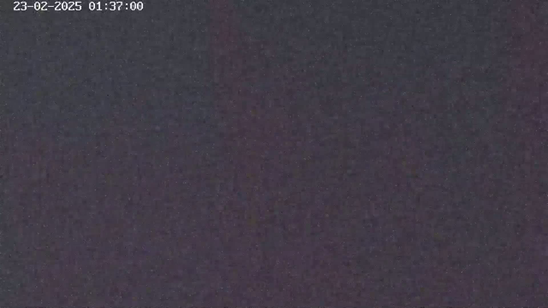 The image shows a dark, grainy, and blurry view of the night sky.
