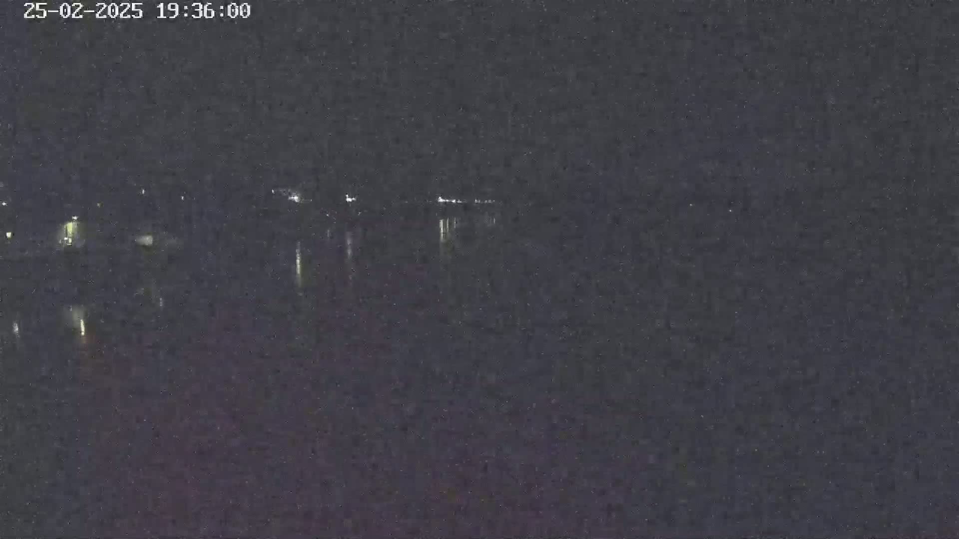 A nighttime, low-light view of a body of water reflecting distant lights.