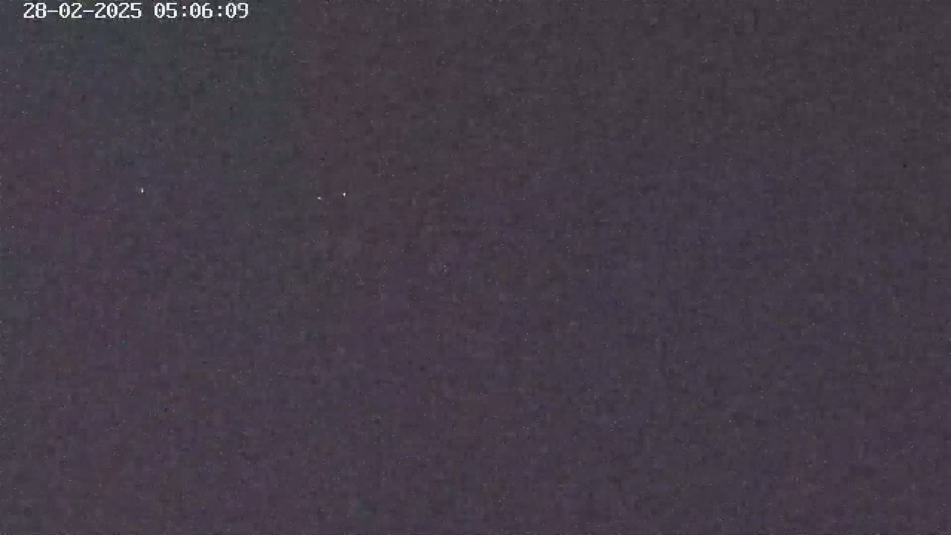 A dark, grainy image shows a mostly featureless night sky.