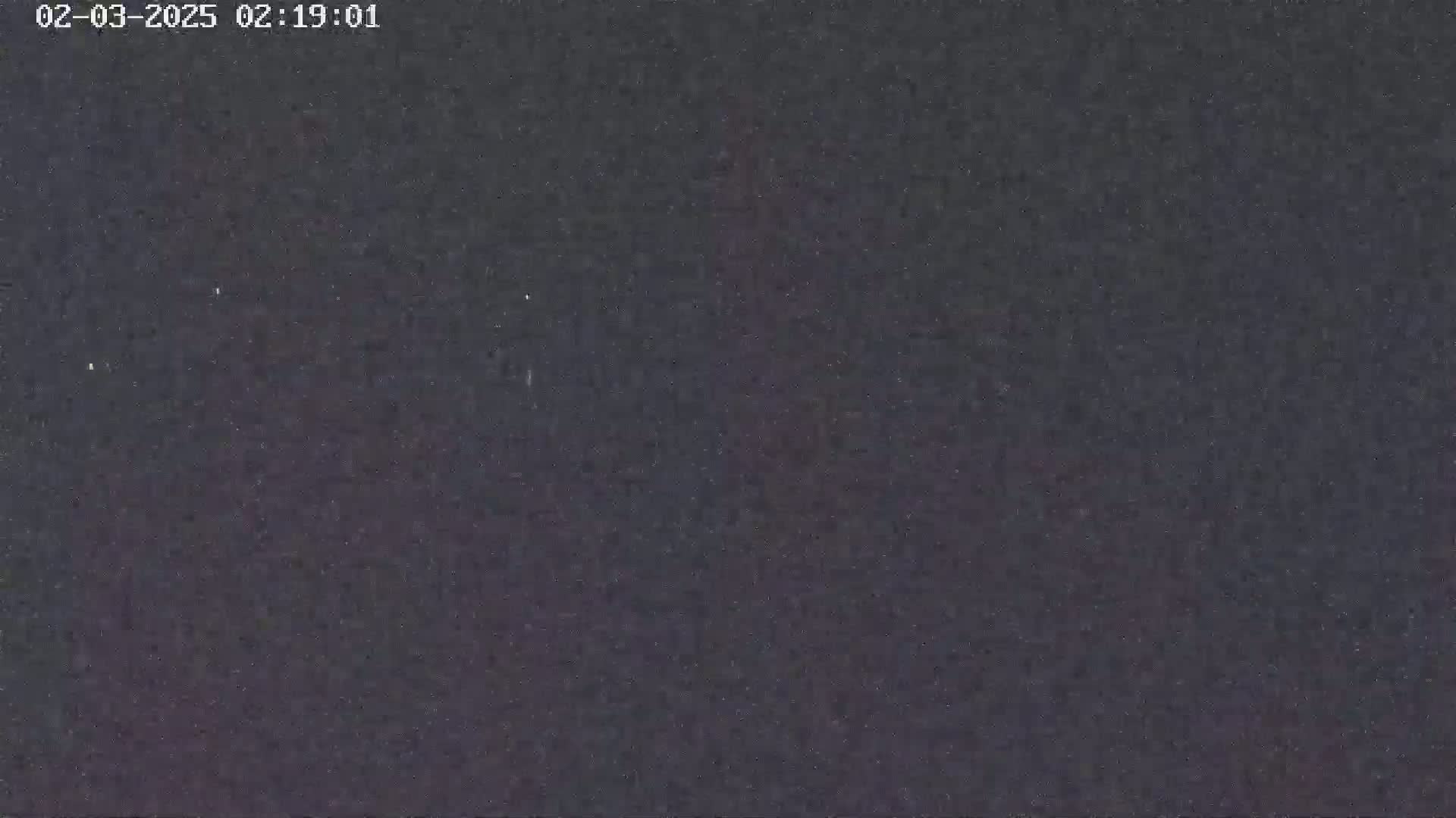 The image shows a dark, grainy nighttime sky.