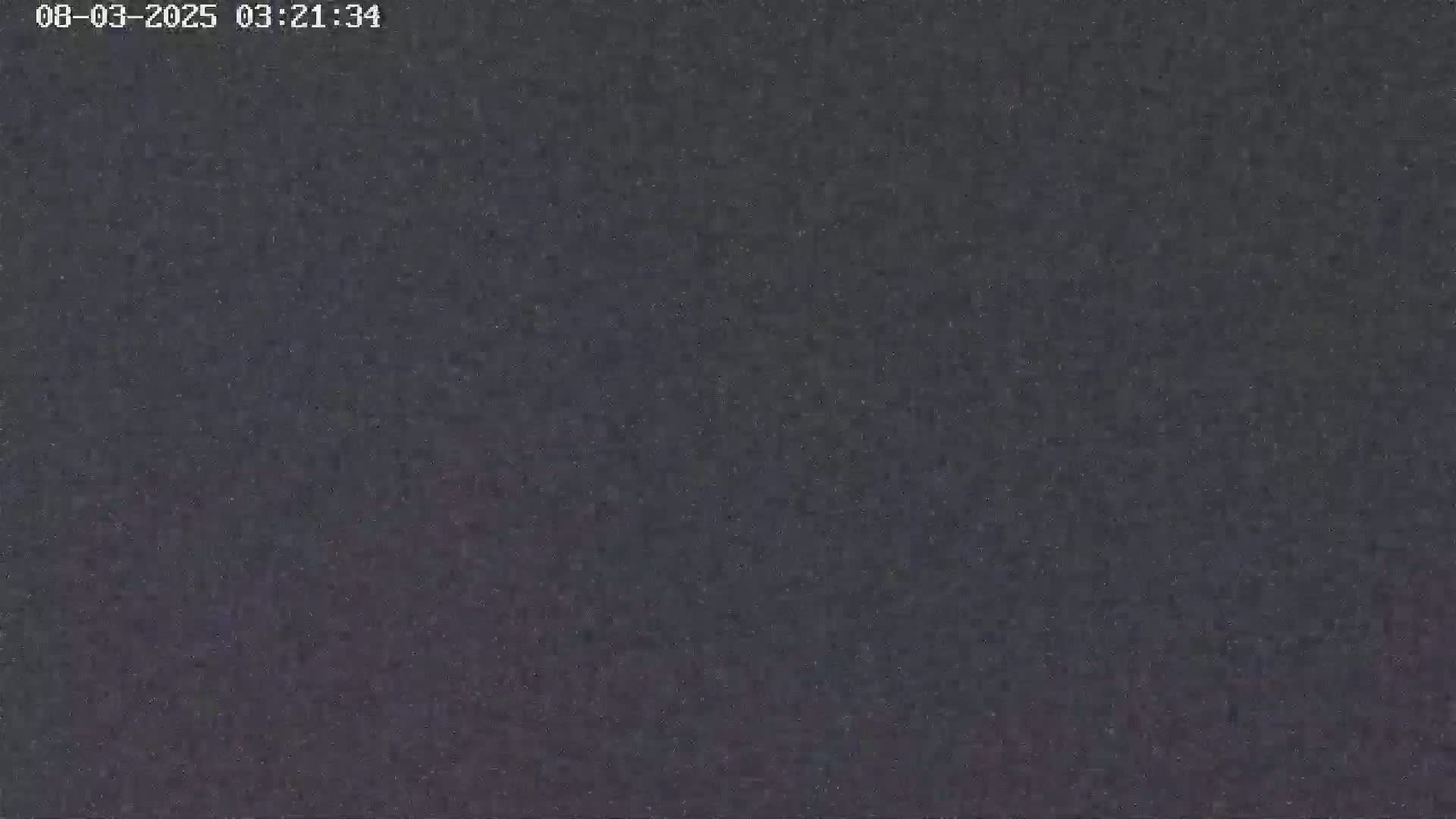 The image shows a dark, grainy, textured surface.