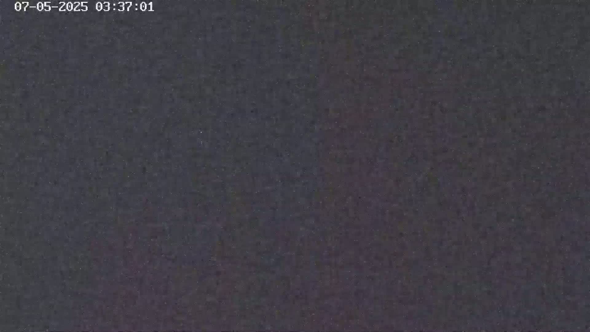 A dark, grainy image shows a nighttime sky.