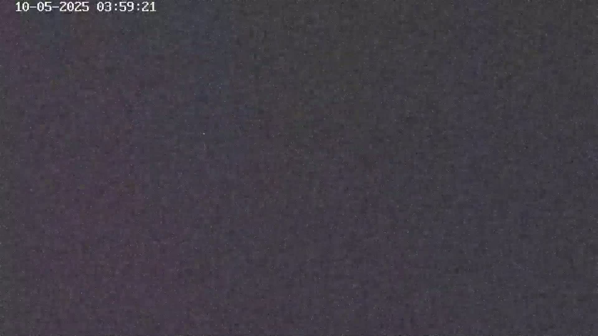 The image shows a dark, grainy surface at night.