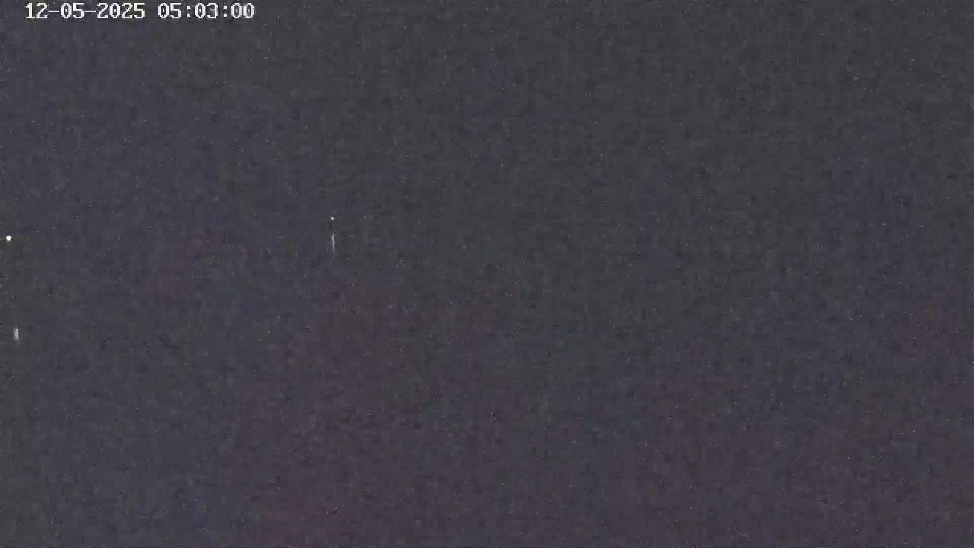 A dark, nighttime sky shows a few faint lights.