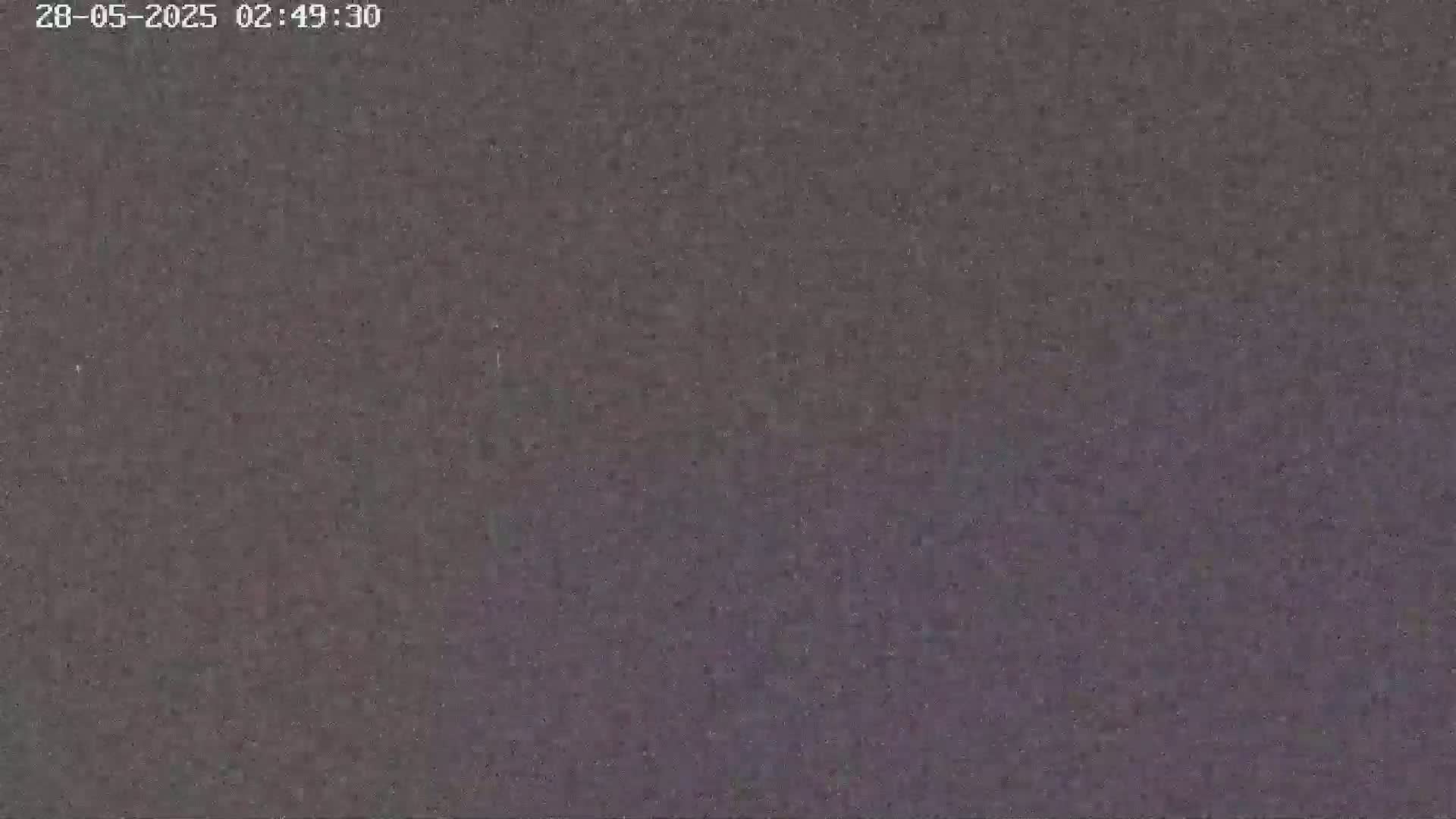 The image shows a dark, grainy, and blurry view, possibly of nighttime conditions outdoors.