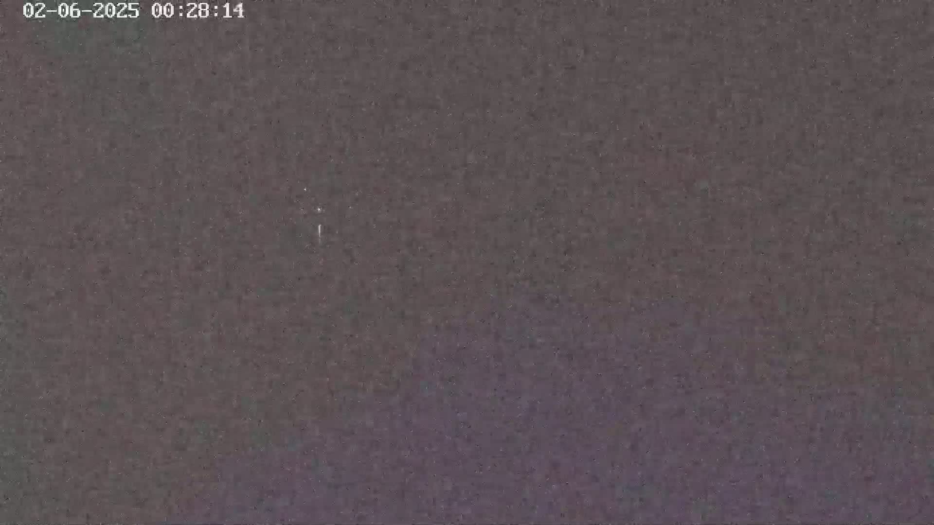 A dark, grainy image shows a mostly clear night sky.