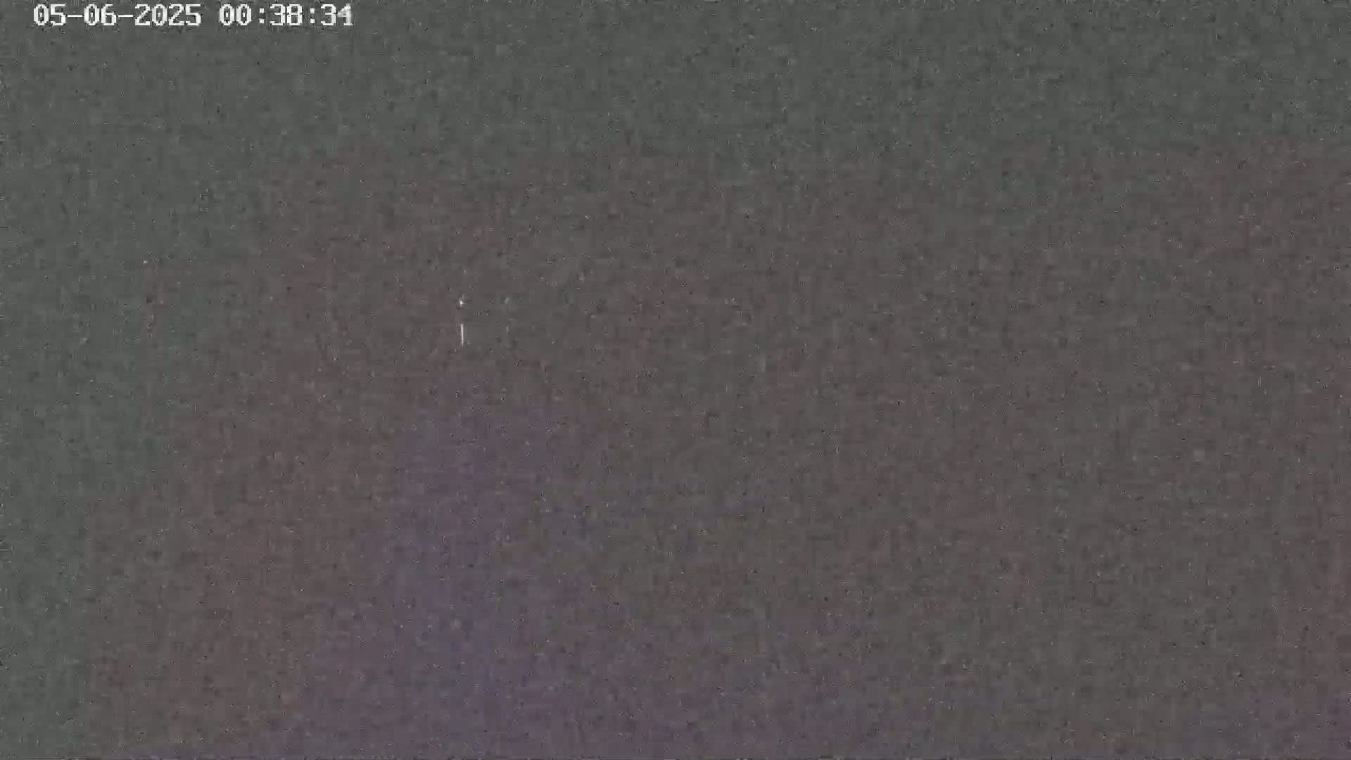 The image shows a dark, grainy, mostly uniform surface.