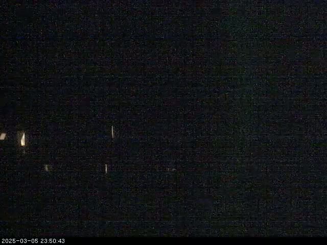 A very dark nighttime scene shows faint lights in the distance.
